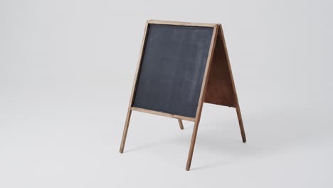 video of blackboard sign on wooden stand with copy space on white background