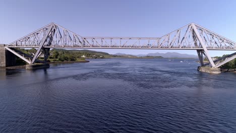 Aerial-drop-down-shot-and-push-in-under-the-Connel-Bridge-revealing-the-landscape-and-the-mountains-of-Mull