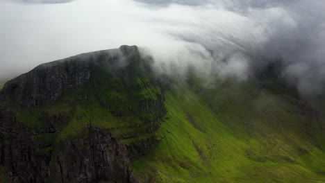 clouds rolling over hilltops in remote faroe islands countryside, aerial view