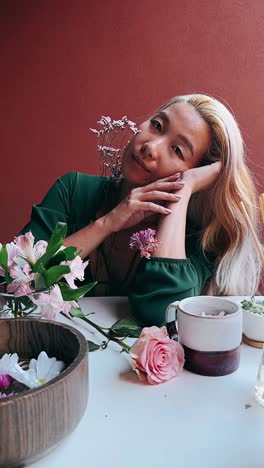 woman surrounded by flowers and home decor items