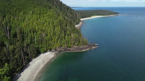 orbital drone shot over coastal beaches and woodland at secret cove, canada