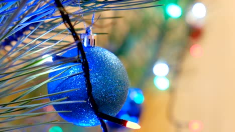 la decoración de navidad y año nuevo. las joyas colgantes de cerca. el fondo de vacaciones de bokeh borroso y abstracto. la guirlanda parpadeante. las luces del árbol de navidad parpadeando.