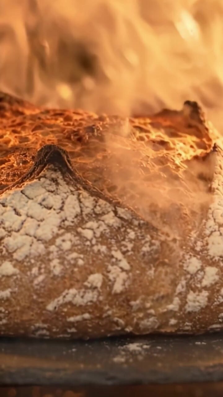 Freshly Baked Artisan Bread Browning in the Oven, Showcasing Its Crisp Crust and Golden Color, Bringing Warmth to the Kitchen Atmosphere