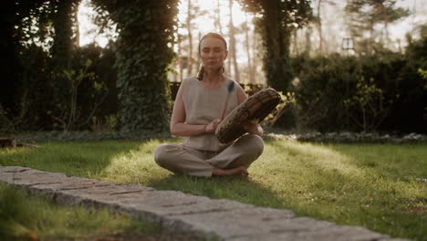 woman meditating and drumming in a garden