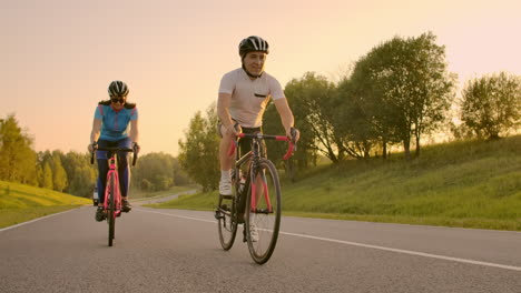 Radfahrer-Fährt-Auf-Rennrad,-Rückansicht.-Radfahrer-Treten-Im-Stadtpark-Mit-Rennrad-In-Die-Pedale.-Kamerafahrt-Eines-Radfahrers-Auf-Rennrad-Bei-Sonnenuntergang.-Intensives-Training-Eines-Radsportlers-Auf-Dem-Fahrrad