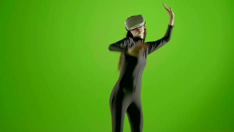 attractive girl young fashion model wearing a vr headset shot in green screen studio . interactive futuristic gesture . medium s