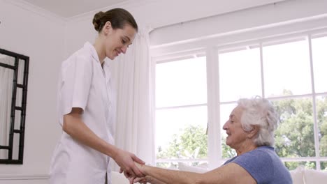 Smiling-nurse-helping-senior-woman-doing-exercises