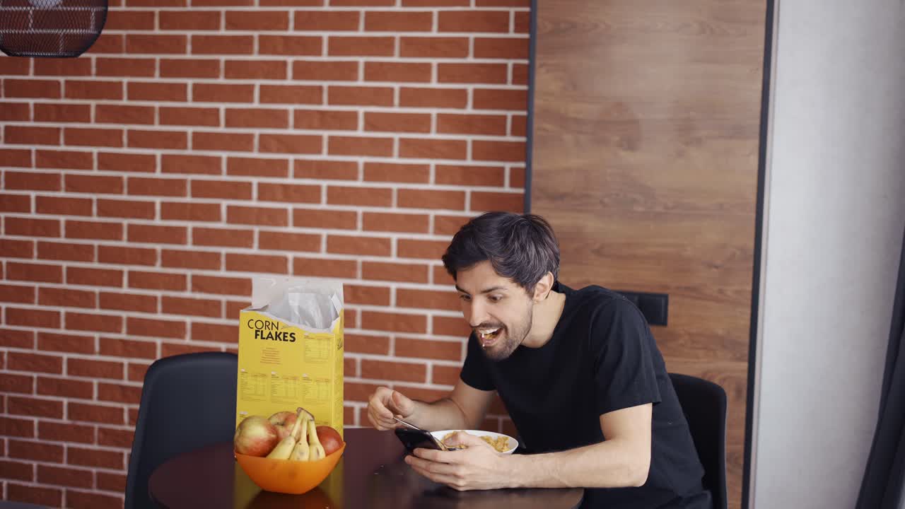 el hombre desayuna y usa el teléfono inteligente