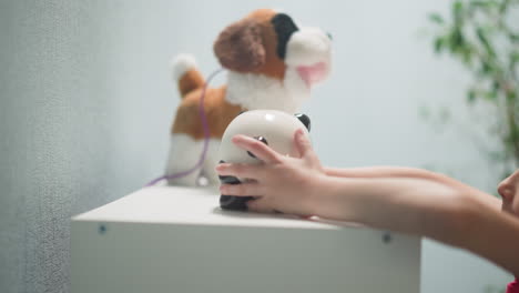 child-takes-full-piggy-bank-in-form-of-panda-from-rack