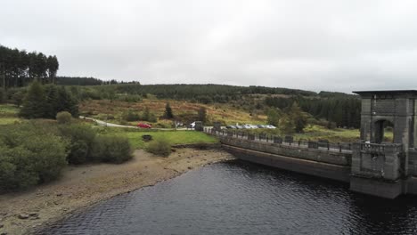 Alwen-reservoir-industrial-hydroelectric-landmark-historical-rural-lake-dam-building-aerial-pull-back-over-lake