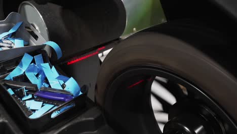 close up of a tire being measured by an aligning machine in a garage