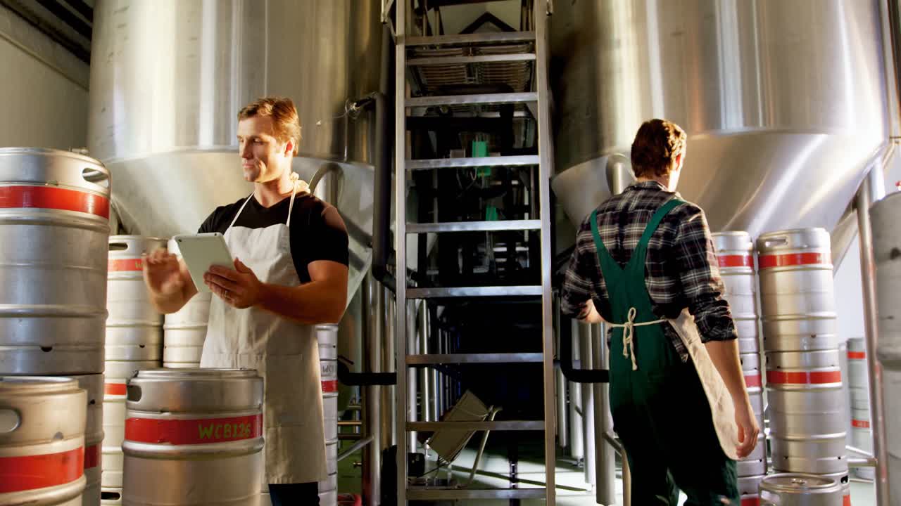 Two brewers maintaining record on digital tablet 4k