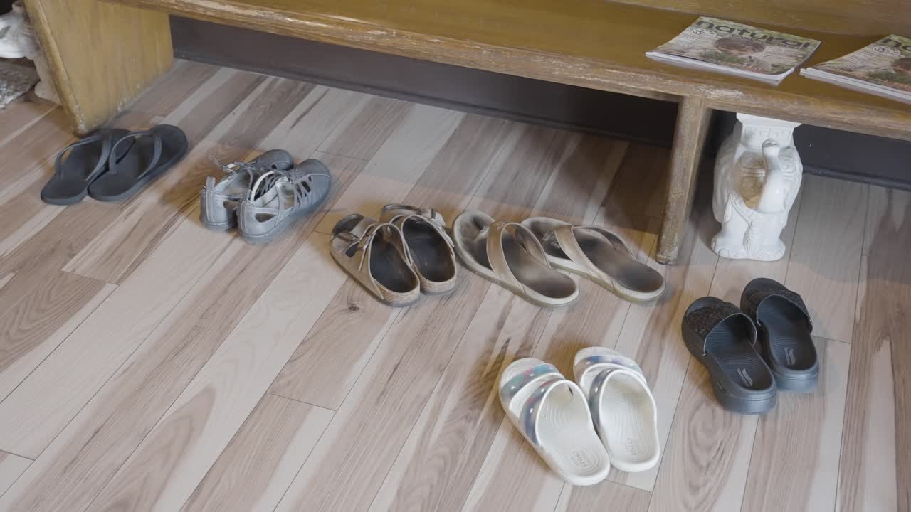 Nello scatto, c'è un'immagine che mostra una varietà di pantofole e scarpe