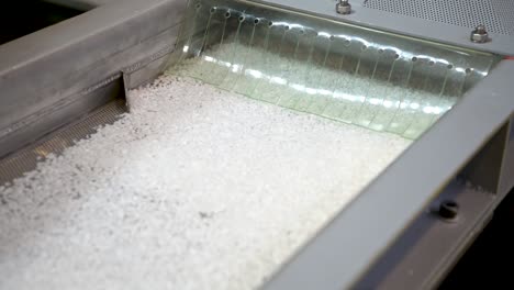 transportador vibratorio. gránulos de plástico blanco se mueven bajo la influencia de la vibración