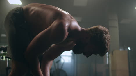 time to rest. young athletic man in sportswear looking exhausted while standing in front of windows at gym.