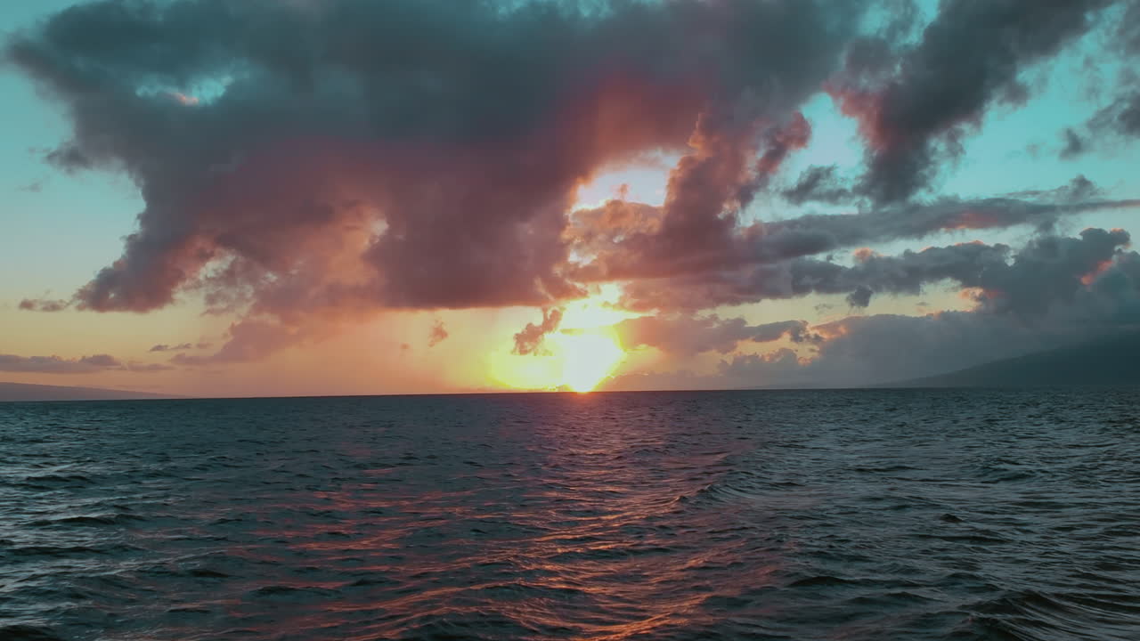 este es un video de una hermosa puesta de sol tomada en un velero frente a la costa de maui, hawaii