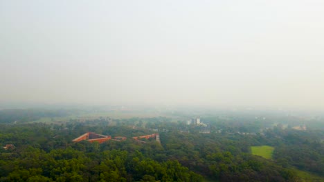 aerial drone view forested jahangirnagar university building bangladesh. cloudy misty foggy day