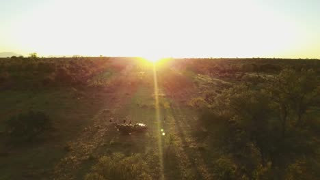 una impresionante toma de avión no tripulado de un grupo de amigos disfrutando del atardecer durante una hermosa puesta de sol africana