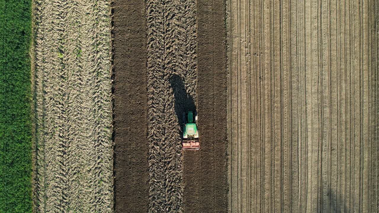 View from Above of Tractor Cultivating Soil for Spring Planting on a Beautiful Morning, Agricultural Theme in the Background