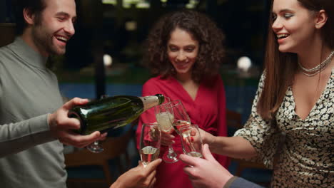 friends pouring drink glasses on celebration meeting in fancy restaurant cafe.