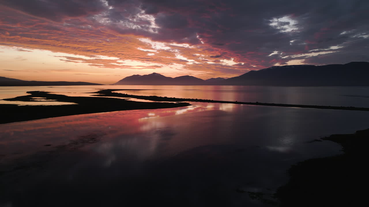 Peaceful Icelandic lake and mountains at golden hour with colorful sky