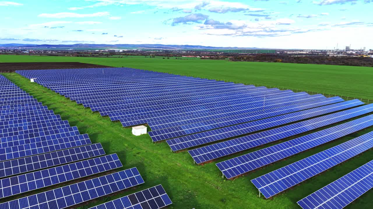 Vast solar panel array in a green field under clear blue skies