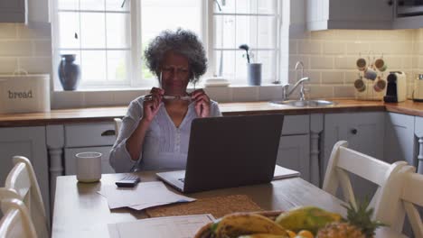 Gestresste-ältere-Afroamerikanische-Frau-Benutzt-Laptop-Und-Berechnet-Zu-Hause-Finanzen