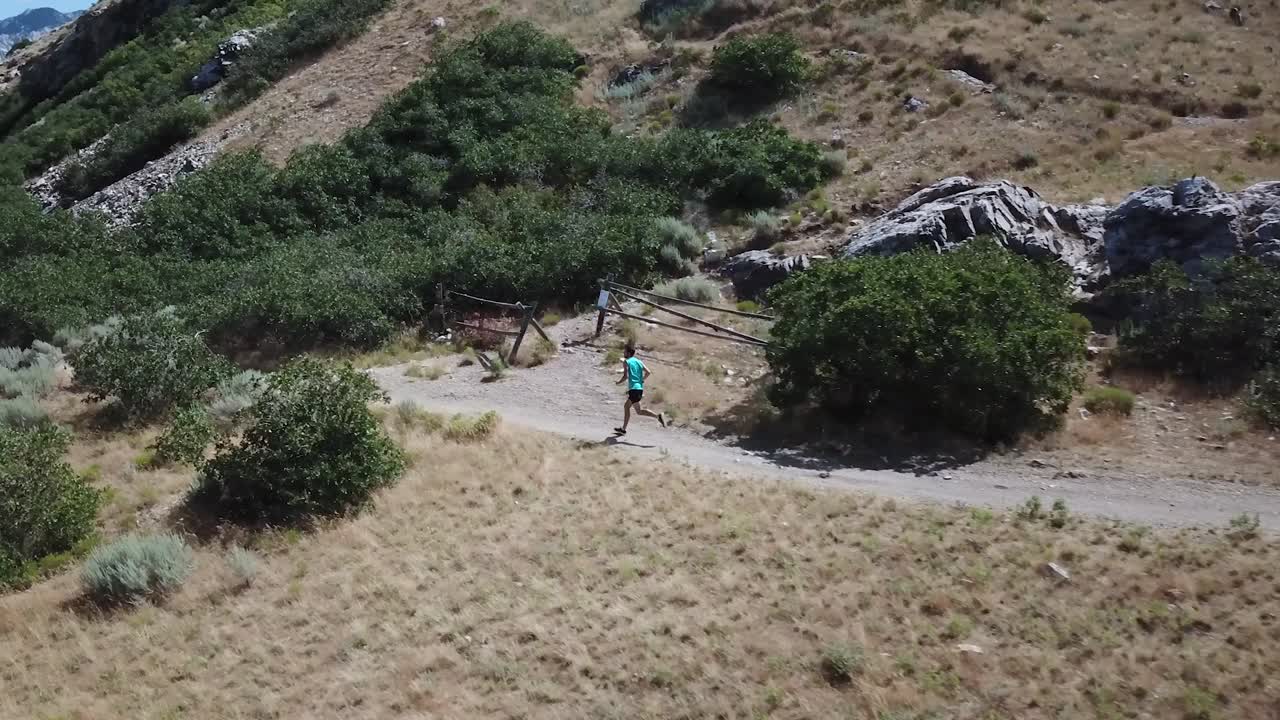 disparo de un dron siguiendo a un hombre activo corriendo por los senderos de montaña al aire libre de wasatch sobre draper city, utah