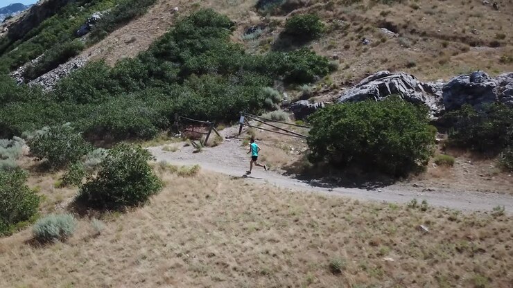 Drone Shot following an active man running on the outdoor Wasatch Mountain trails above Draper City, Utah