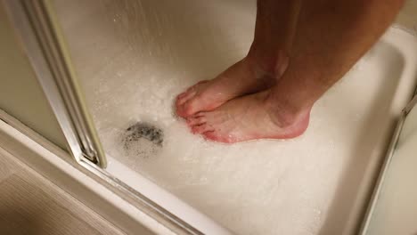 person washing feet in a shower