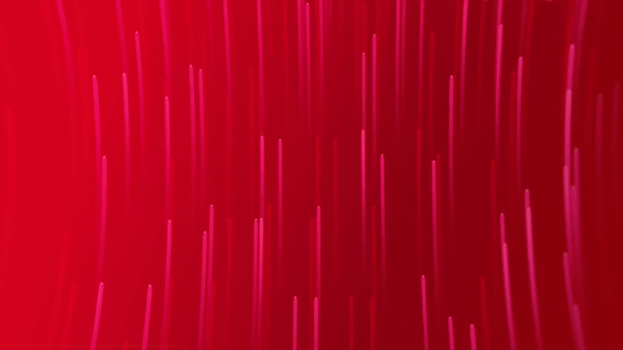 Animation of glowing light trails moving over red background