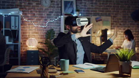 businessman experiencing virtual reality in office at night