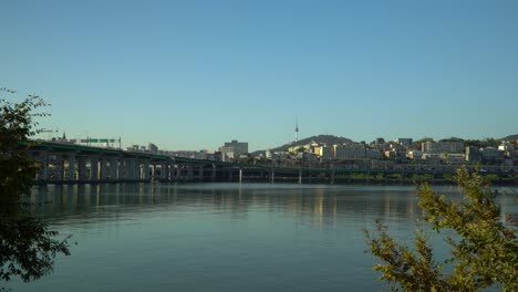 ultrawide view of han river, yongsan district with n seoul tower on namsan mountain and hannam bridge, autumn foliage on cloudless day, south korea static