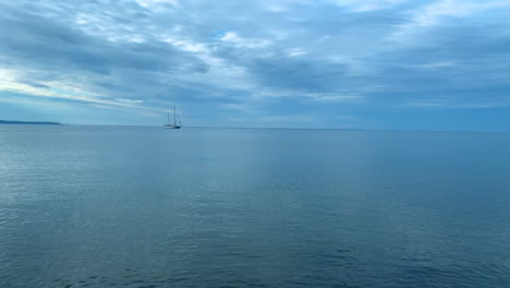 lonely ship on calm sea, small waves and clear blue water, baltic sea in poland rewa