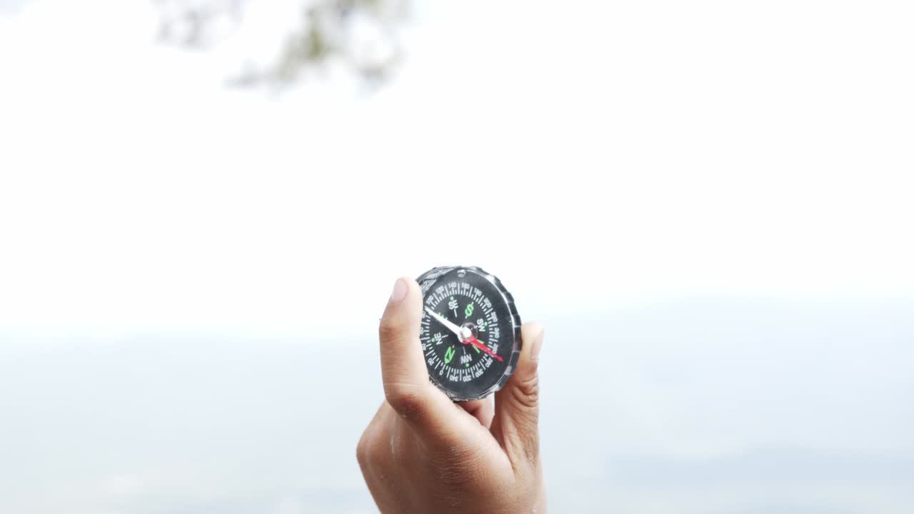 Hand holding a compass for travel.