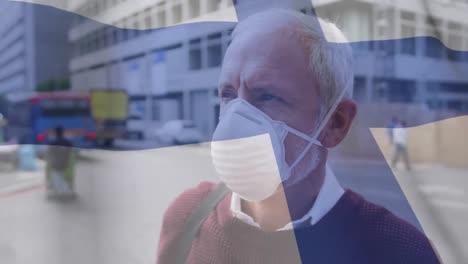 Finland-waving-flag-against-caucasian-senior-man-wearing-face-mask-on-the-street