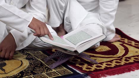 closeup of indian men reading quran holy book