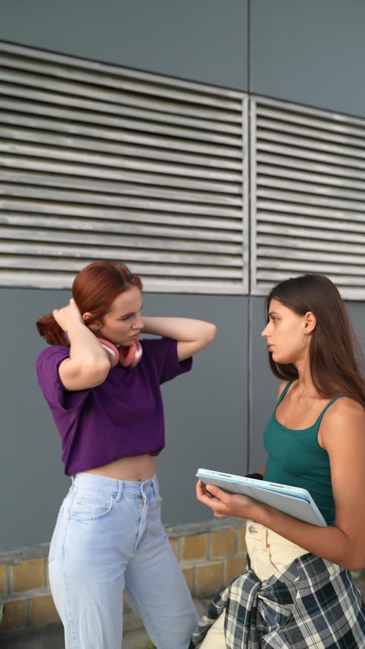 dos mujeres jóvenes teniendo una conversación afuera