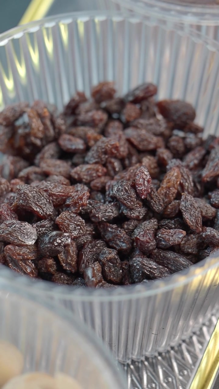 Gros plan sur des raisins secs dans un récipient en plastique transparent