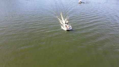 pontoon boat approaching drone camera at full speed