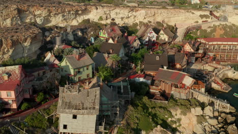 Beautiful-Wide-View-of-mediterranean-Fisher-Village-on-Malta-Island-Gozo,-Small-Wooden-Houses-in-Sunset,-Aerial-Backwards-Dolly