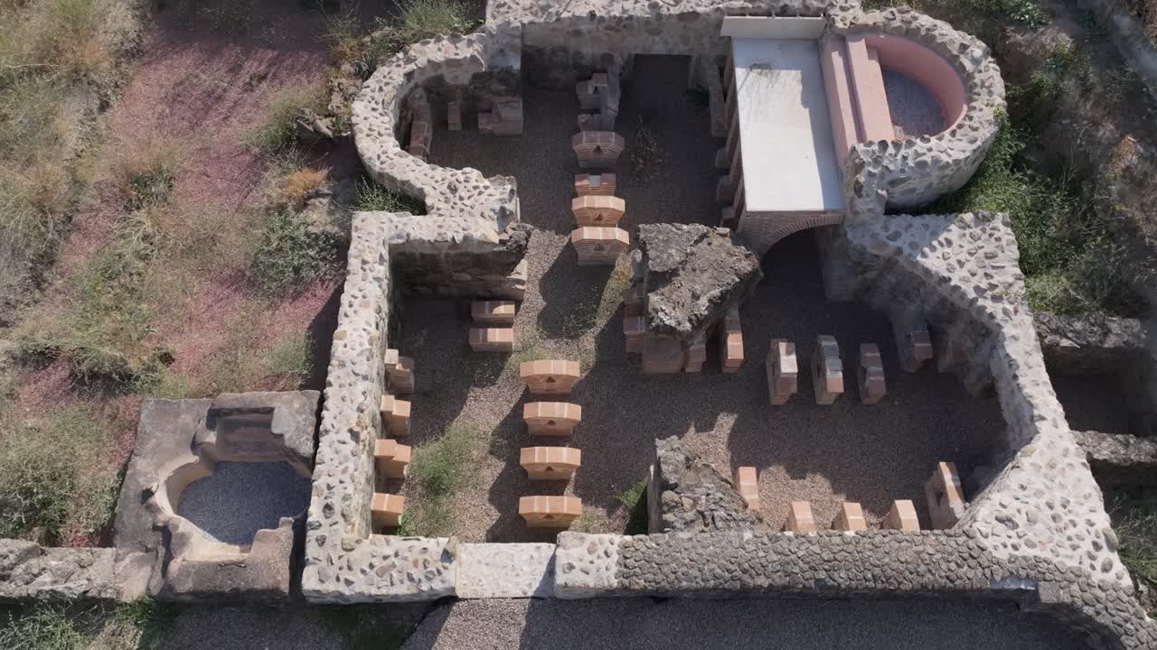 overhead view with a drone on the reconstruction of a Roman villa in situ, we see one of the parts of the house, a small blue area, for the water and the entire transit area is gravel