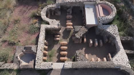 overhead view with a drone on the reconstruction of a roman villa in situ, we see one of the parts of the house, a small blue area, for the water and the entire transit area is gravel