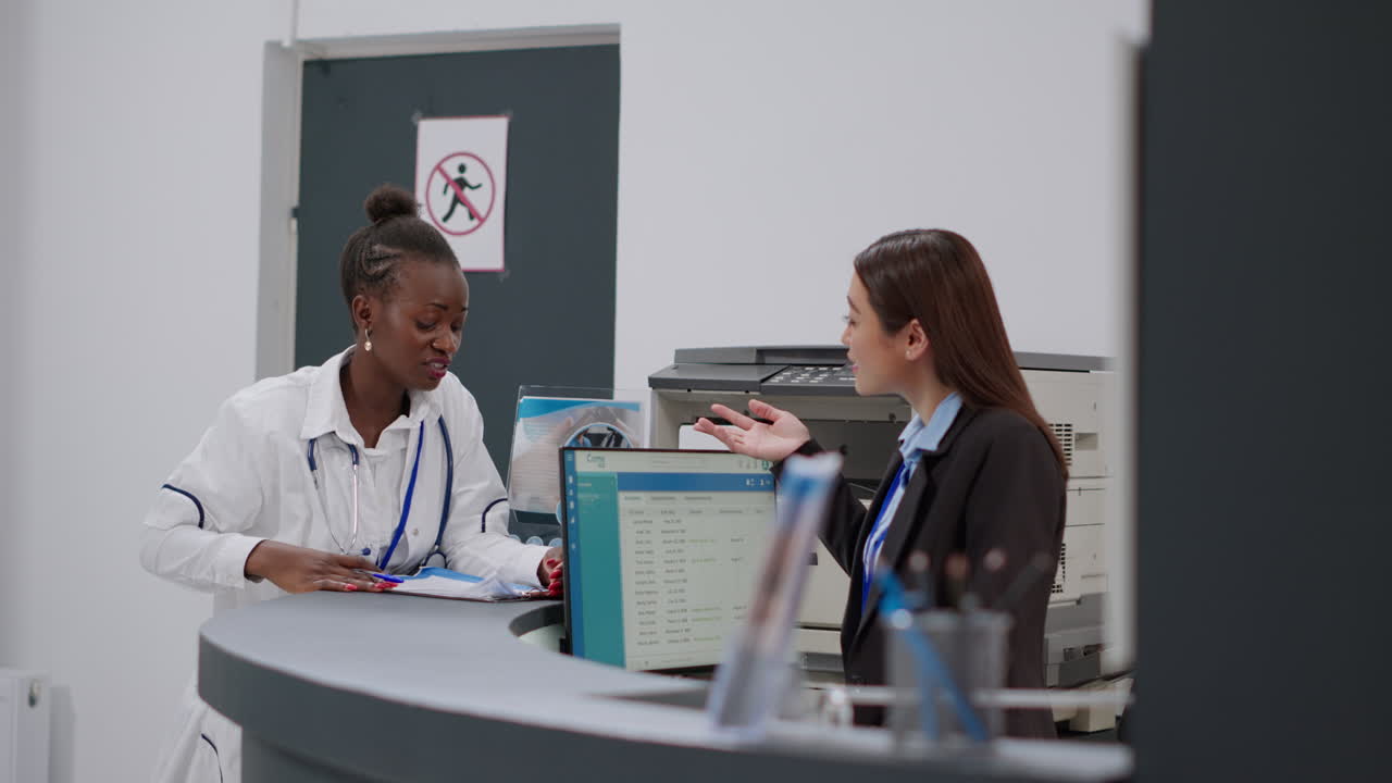 Medical staff assisting patients at a hospital reception desk