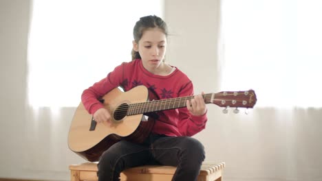 young girl playing guitar and singing