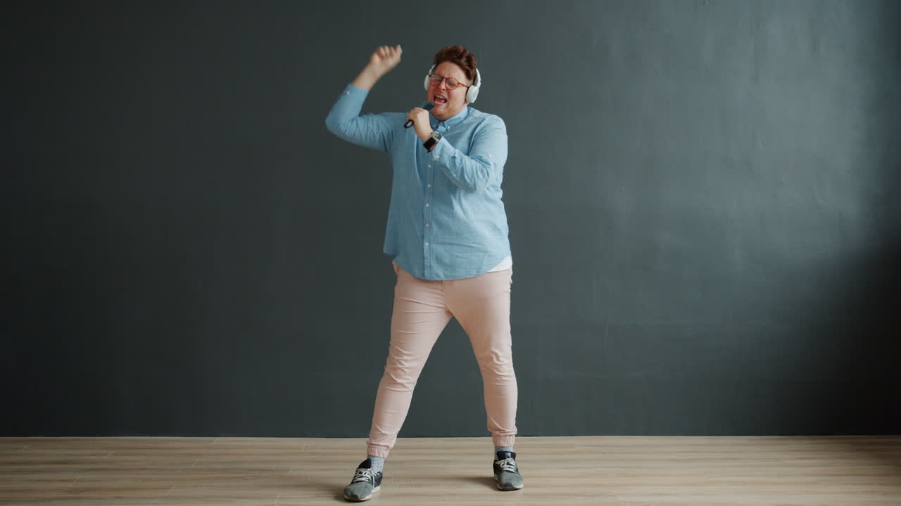 Mand synger og danser med mikrofon