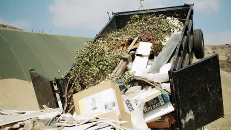 large dumpster overflowing with mixed trash and green waste