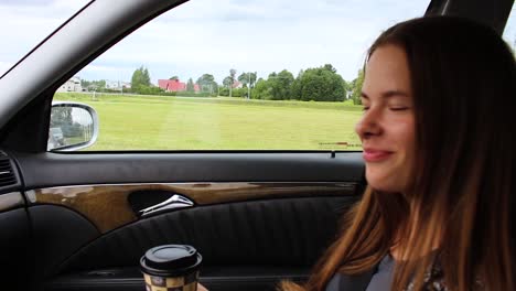 chica tomando café en el auto al lado de la carretera