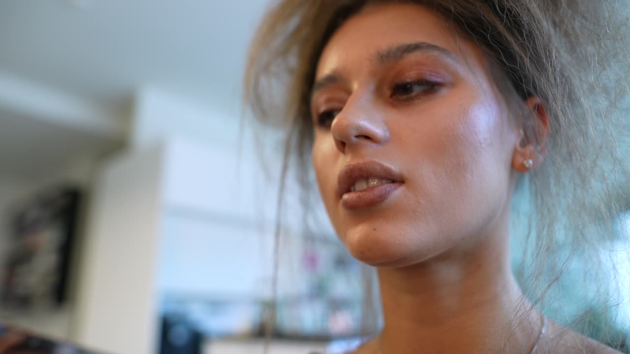Close-up of Young Woman Getting Lipstick Applied with a Brush