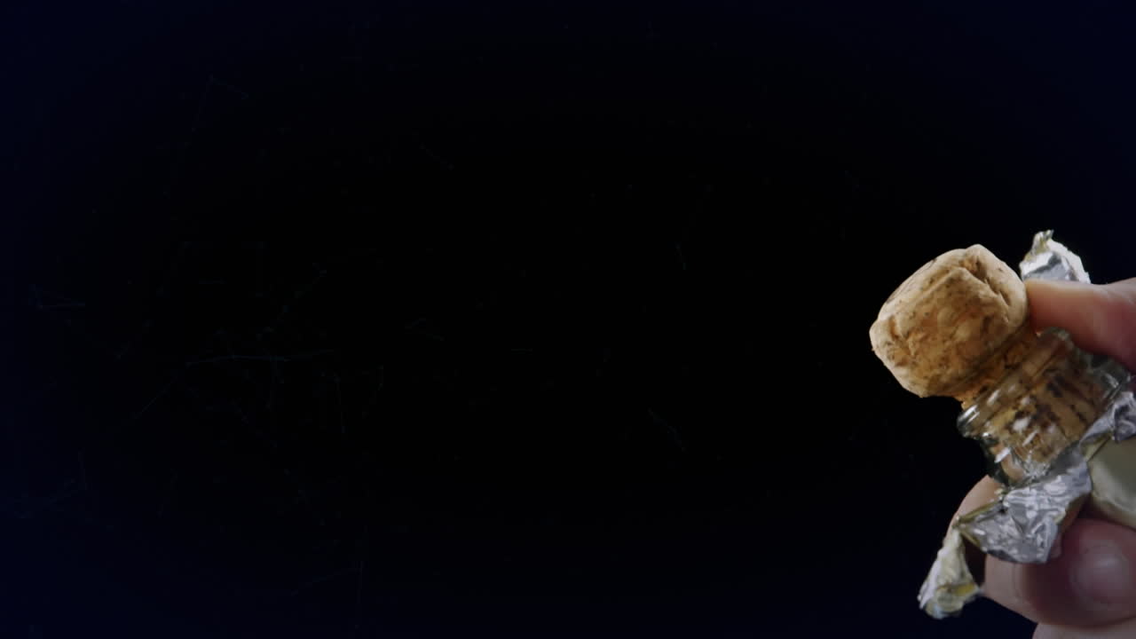 animación de formas sobre el hombre abriendo champán sobre fondo negro